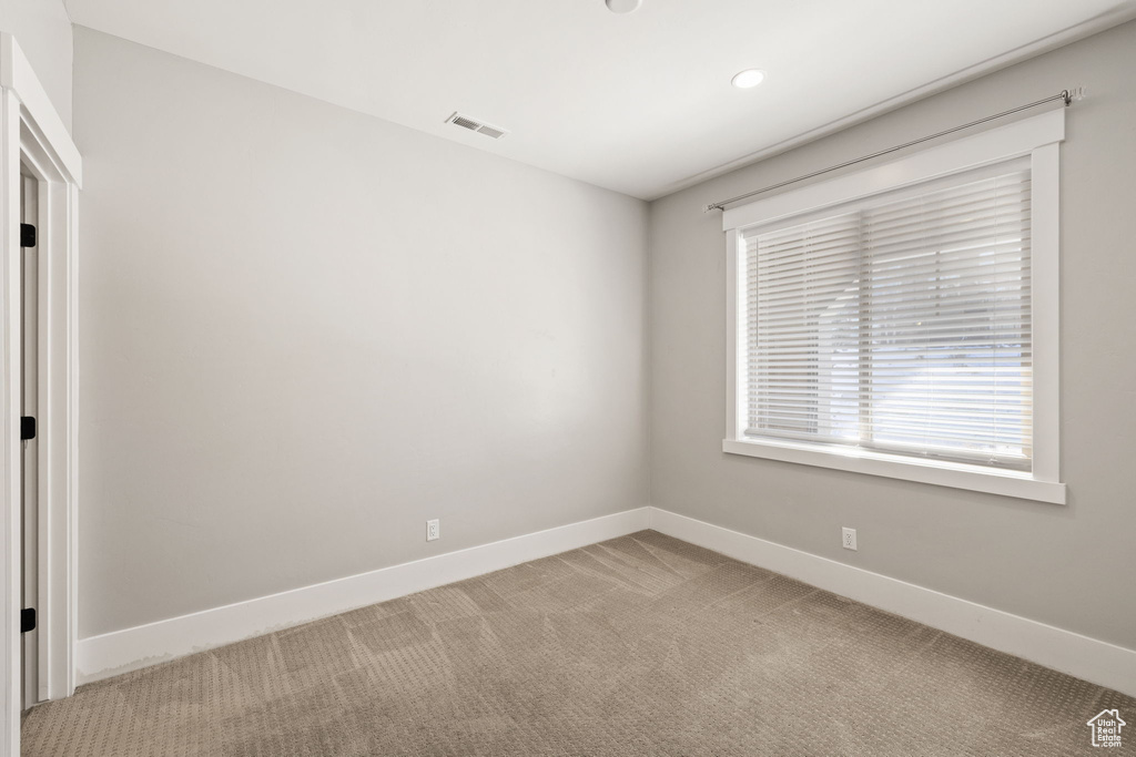 Empty room featuring light carpet, baseboards, and recessed lighting