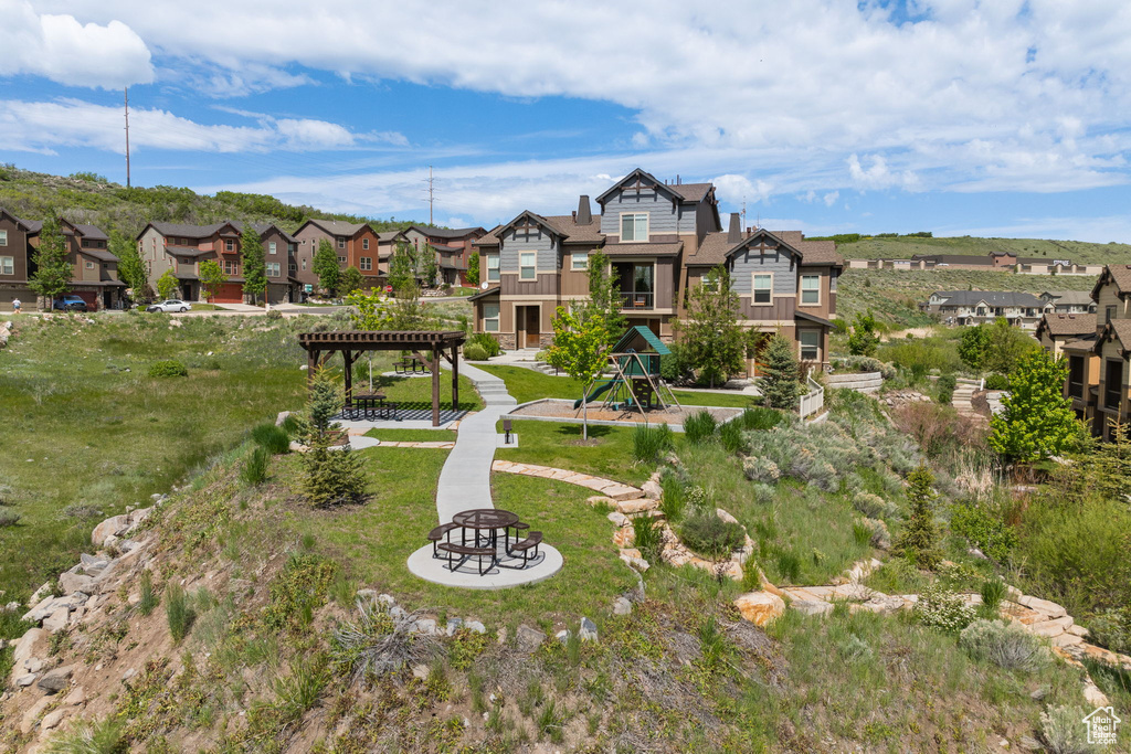 Rear view of property with a residential view, a pergola, and a fire pit