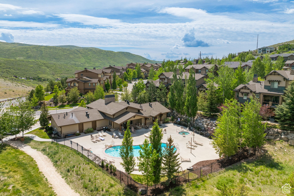 Aerial view of residential area with a pool area and a mountain backdrop