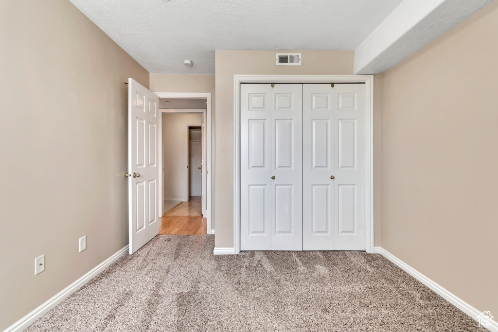 Unfurnished bedroom featuring carpet flooring, a closet, and baseboards