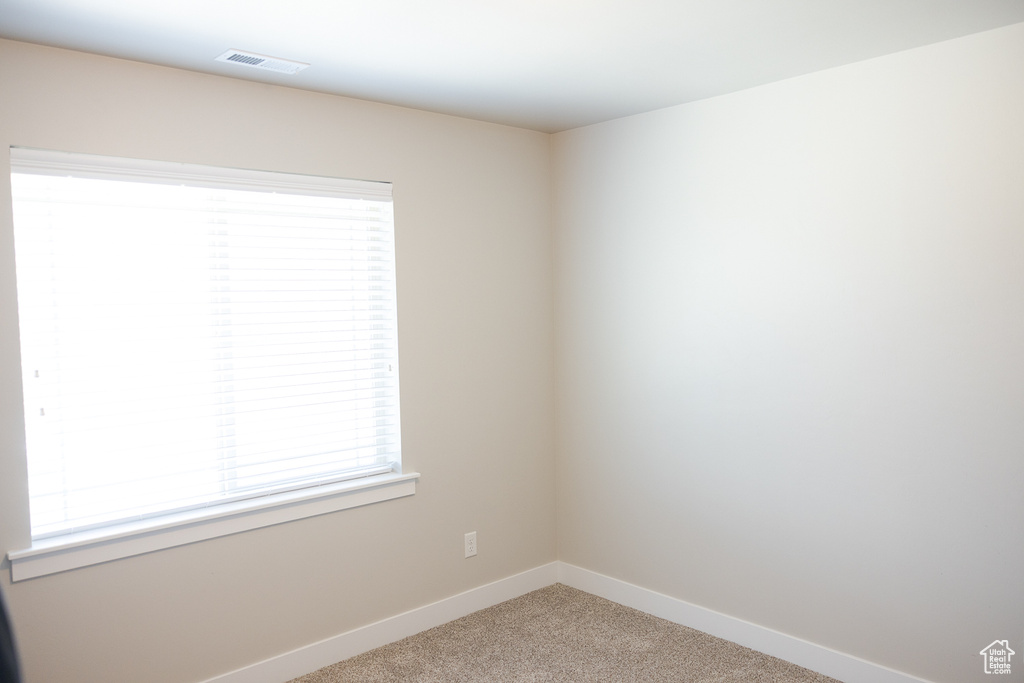 Unfurnished room with light colored carpet and baseboards