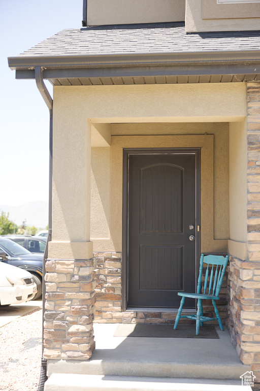 Property entrance featuring stone siding and stucco siding