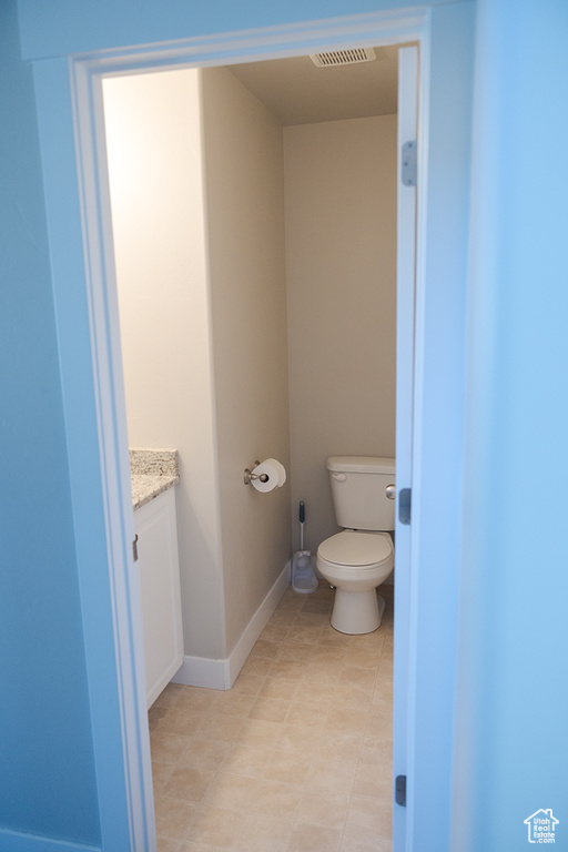 Bathroom with vanity, toilet, tile patterned floors, and baseboards