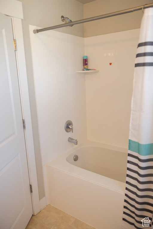 Full bath with shower / bath combo with shower curtain and tile patterned flooring