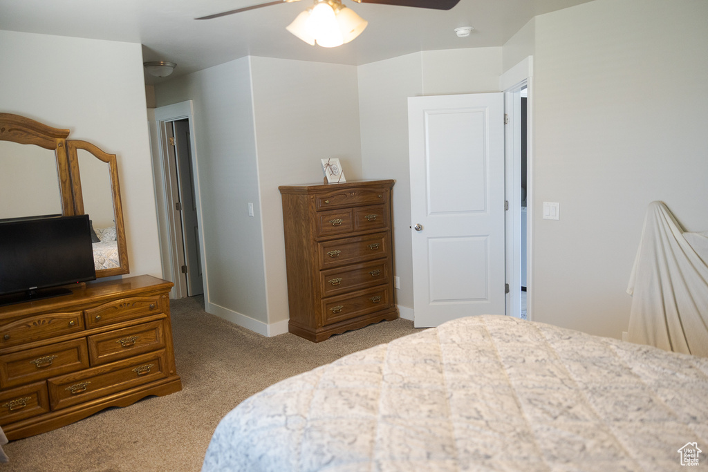 Bedroom featuring light colored carpet, ceiling fan, and baseboards