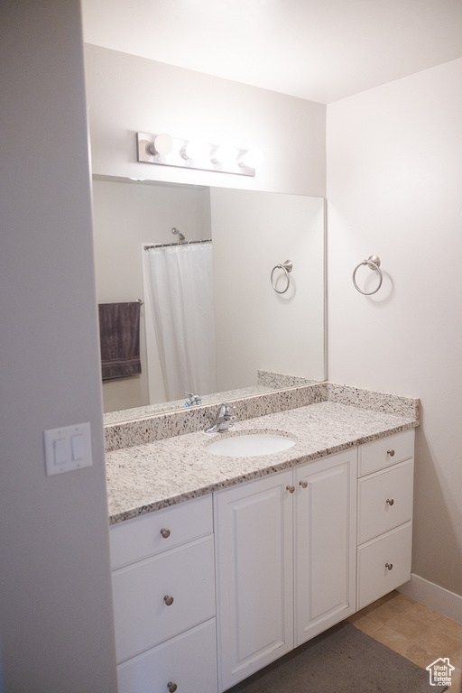Full bath with vanity and baseboards