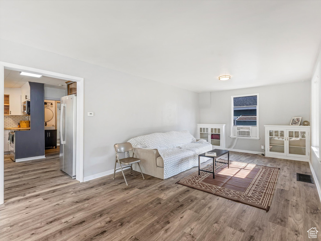 Living area featuring wood finished floors, baseboards, and cooling unit