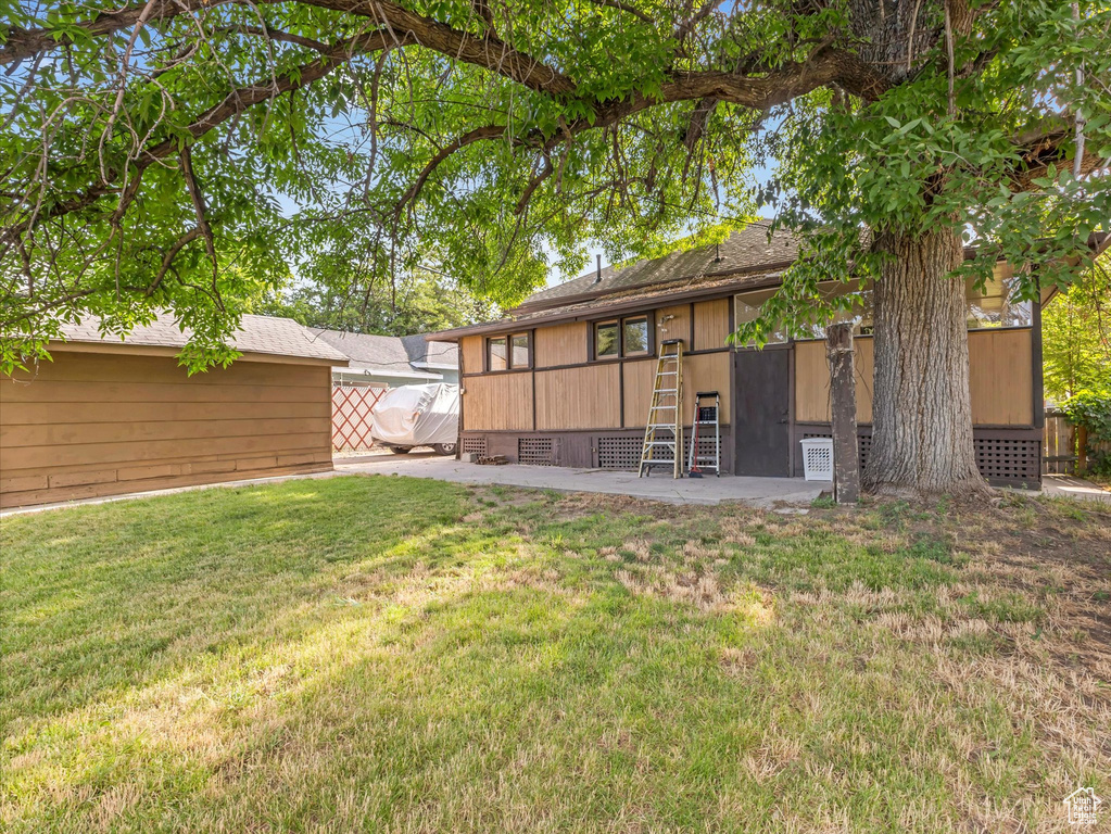 Back of property with a lawn and a patio area