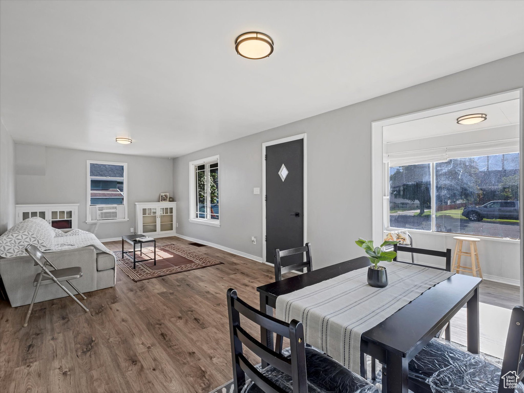 Dining space with wood finished floors, cooling unit, and baseboards