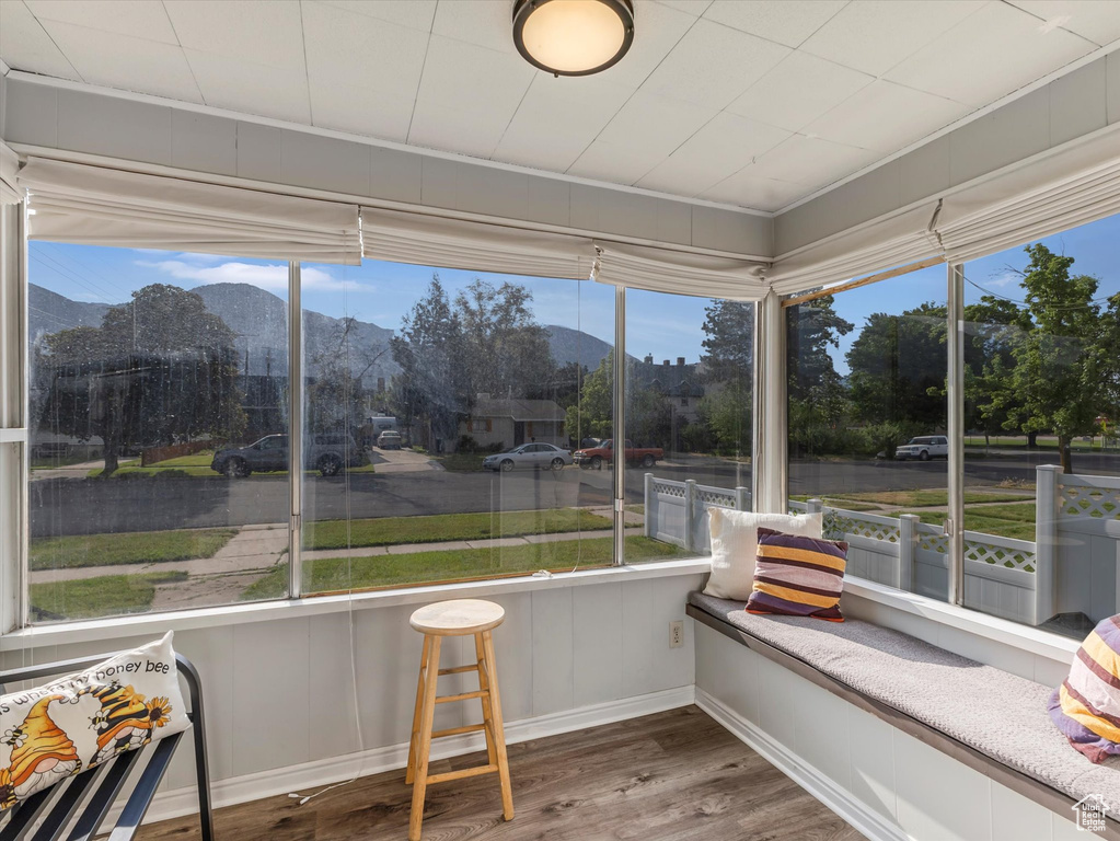 Sunroom / solarium with wood finished floors, a mountain view, and baseboards