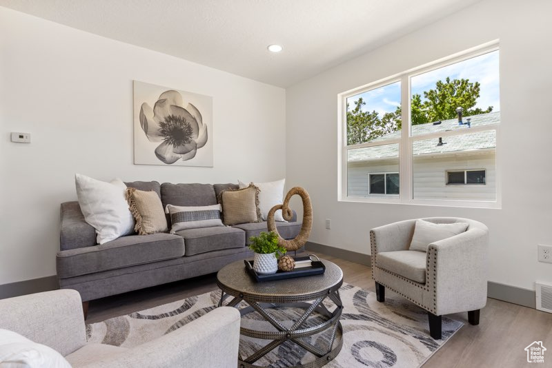 Living room with light wood-style flooring, baseboards, and recessed lighting