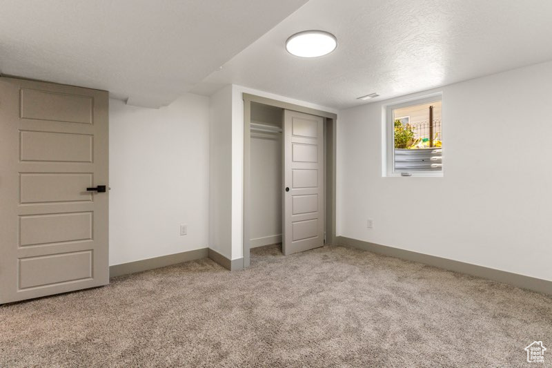 Unfurnished bedroom featuring carpet flooring, baseboards, and a closet