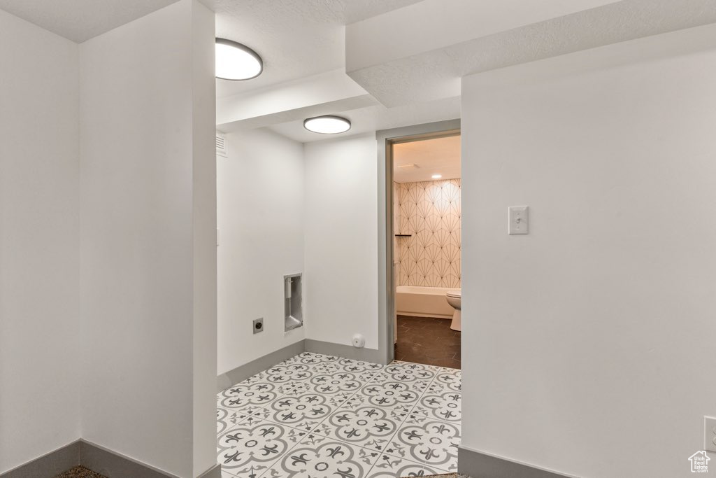 Laundry area with electric dryer hookup and baseboards