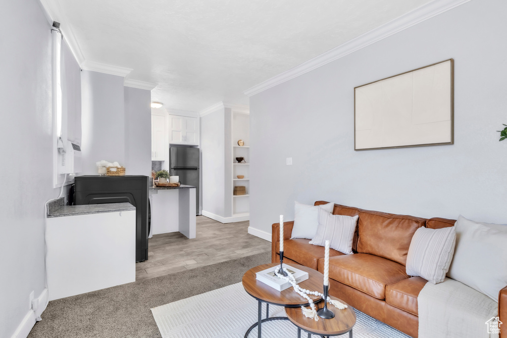 Living room featuring ornamental molding, light carpet, and baseboards