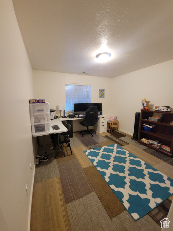 Office space with baseboards and a textured ceiling