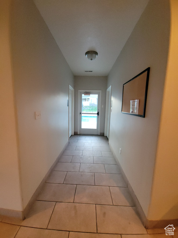 Corridor with baseboards and light tile patterned floors