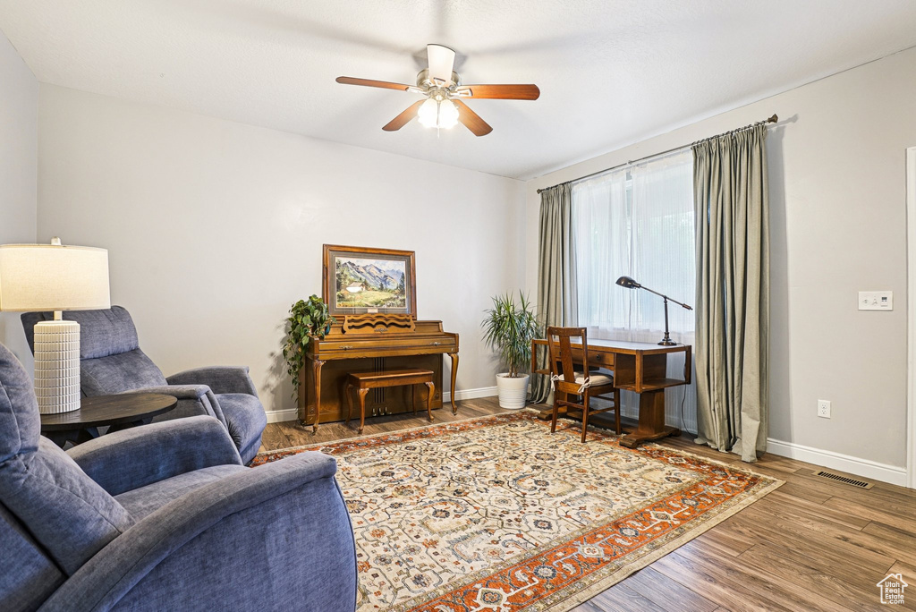 Living area with ceiling fan and wood finished floors