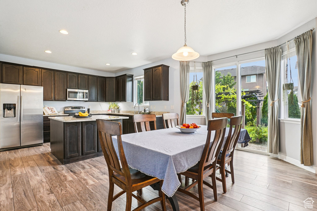 Dining room with light wood-style floors and recessed lighting