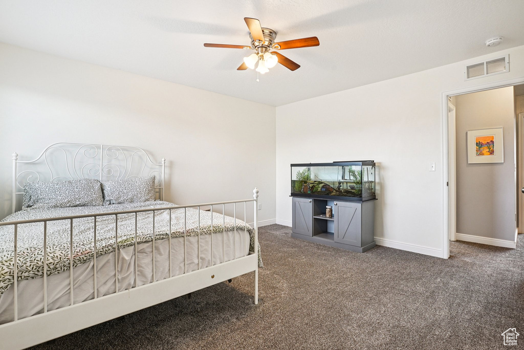 Carpeted bedroom featuring baseboards and ceiling fan