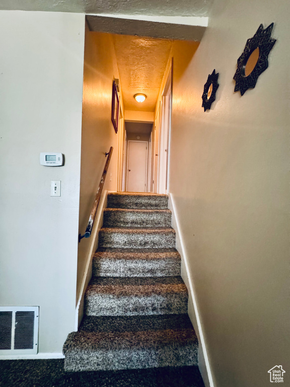 Stairs featuring baseboards and carpet flooring