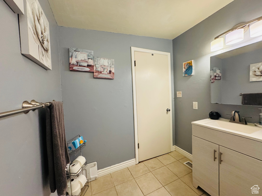 Bathroom featuring vanity, tile patterned flooring, and baseboards