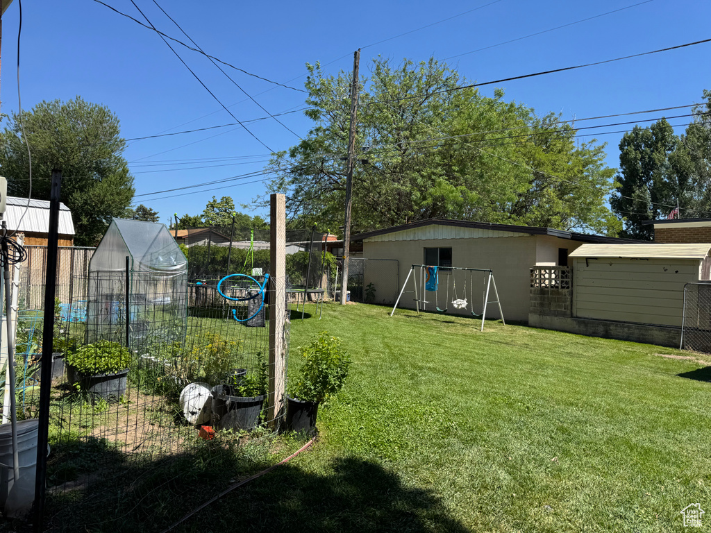 View of yard featuring a playground and a vegetable garden