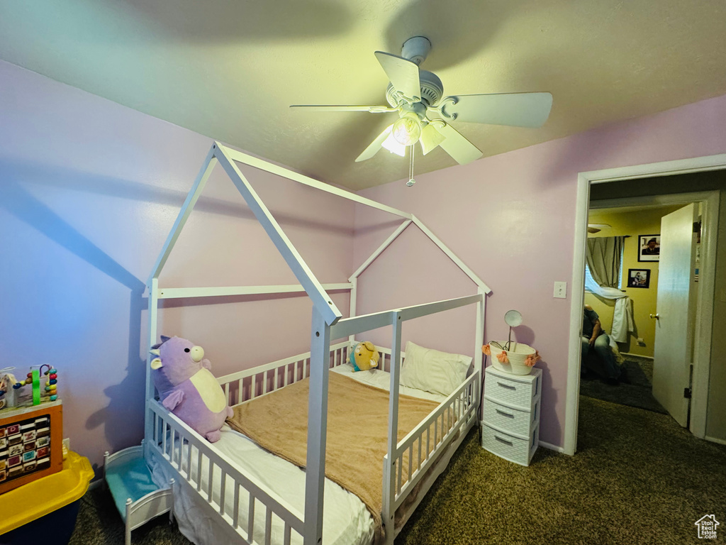 Carpeted bedroom featuring ceiling fan