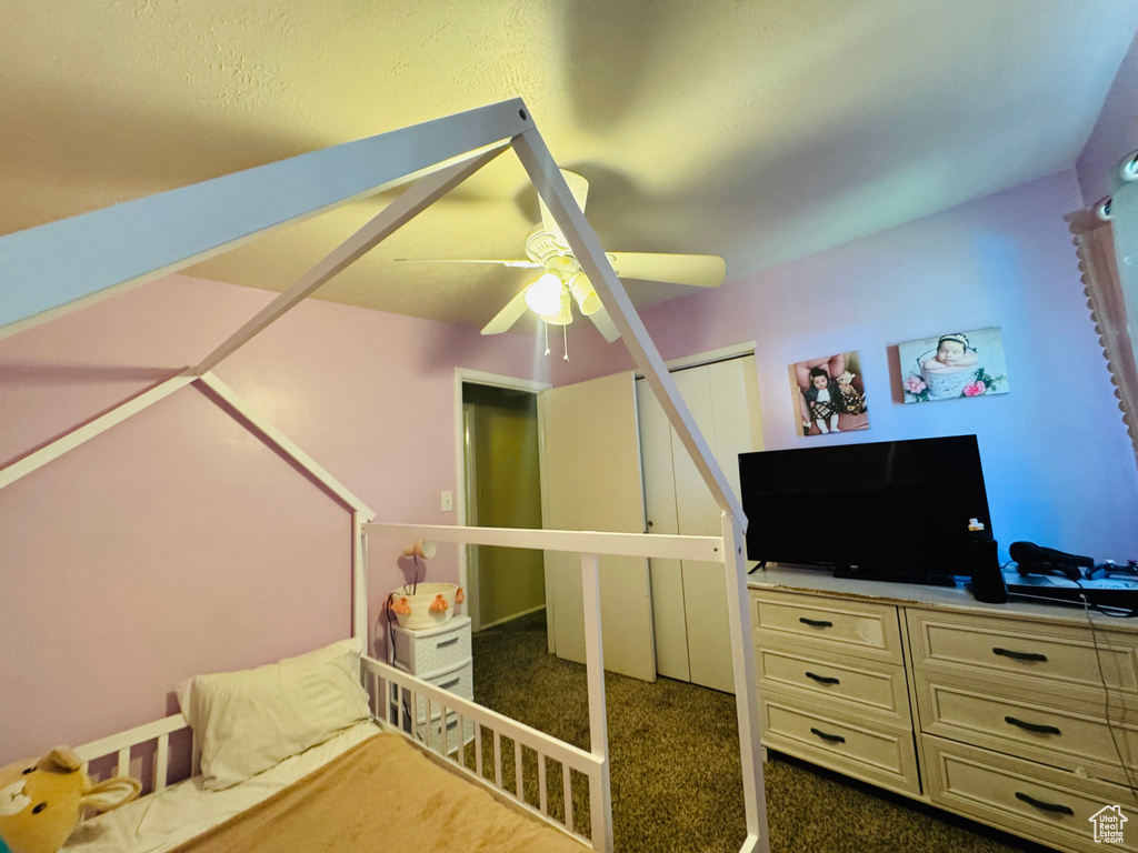 Bedroom featuring dark carpet, a closet, and ceiling fan