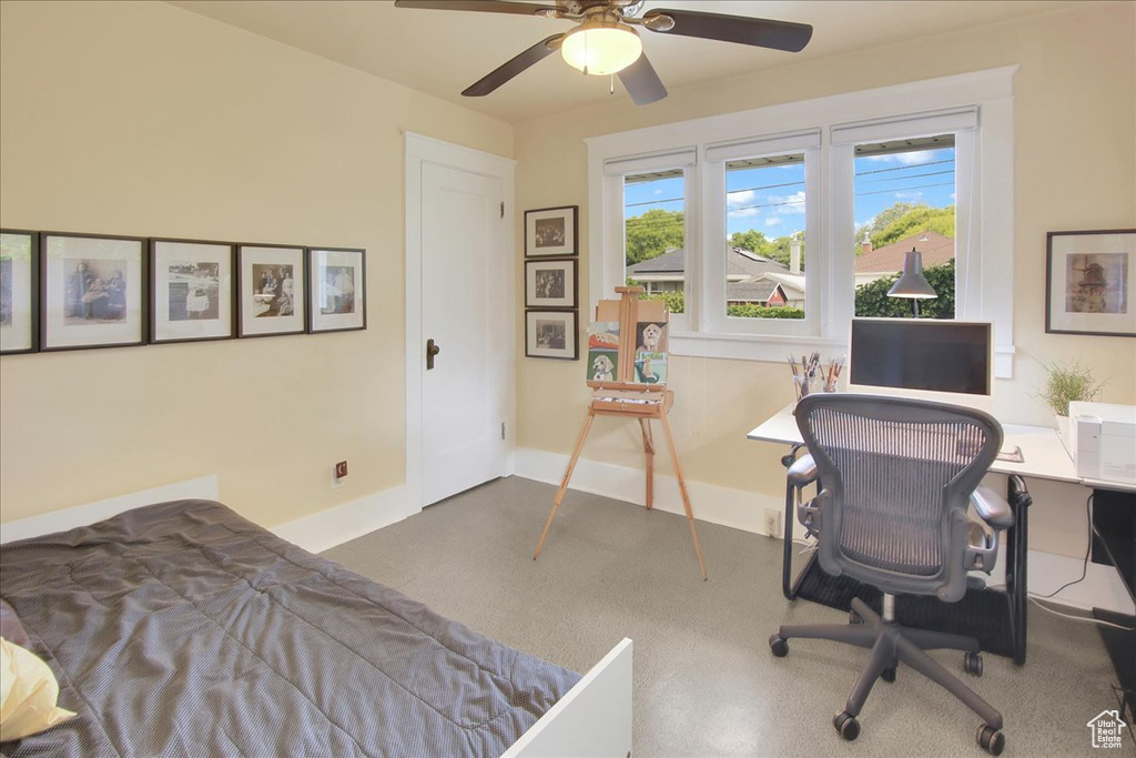Carpeted bedroom with a desk, baseboards, and ceiling fan