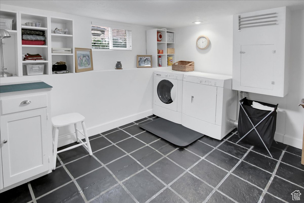 Laundry area with washing machine and clothes dryer, cabinet space, and baseboards