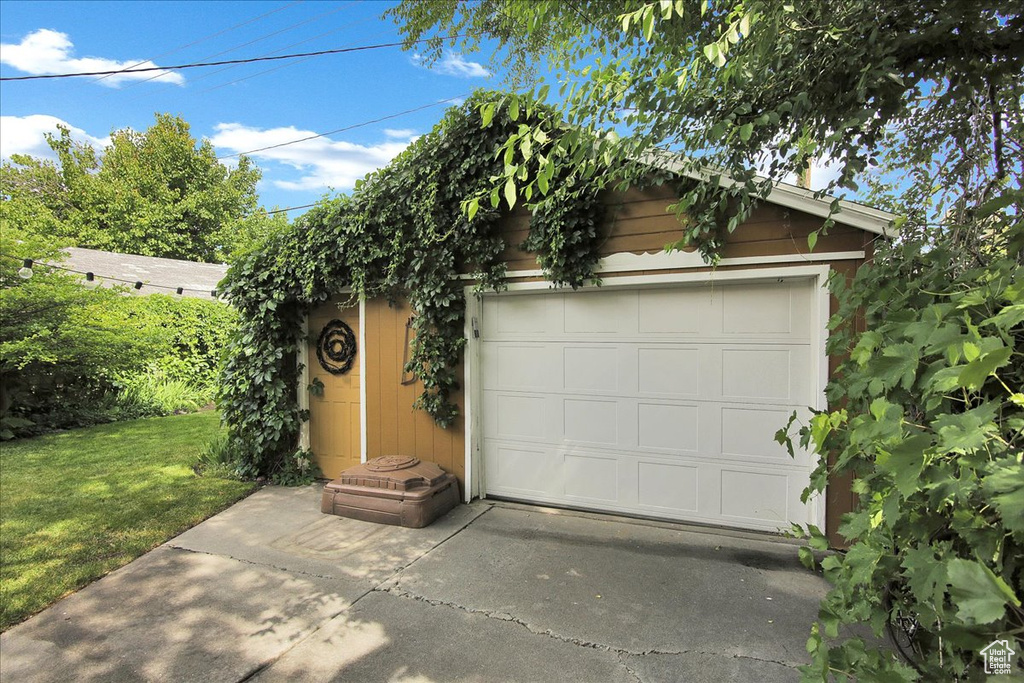 View of front of house with a garage, an outbuilding, and a front yard