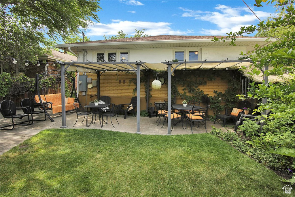 Back of property with a pergola, a yard, a patio, and stucco siding