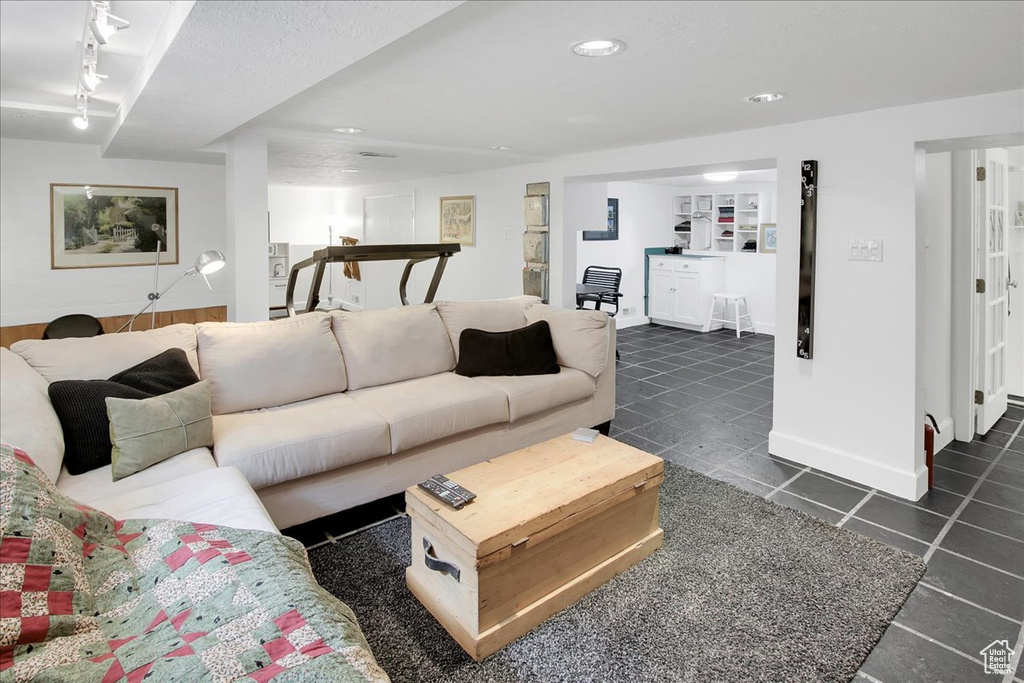 Living room featuring track lighting, dark tile patterned flooring, and recessed lighting