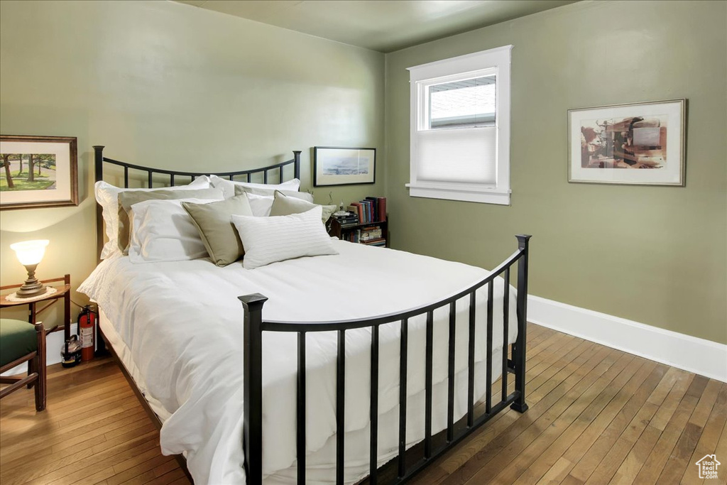 Bedroom with hardwood / wood-style floors and baseboards