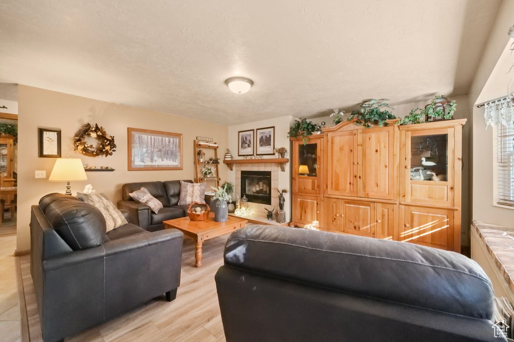 Living area with light wood-style flooring and a tile fireplace