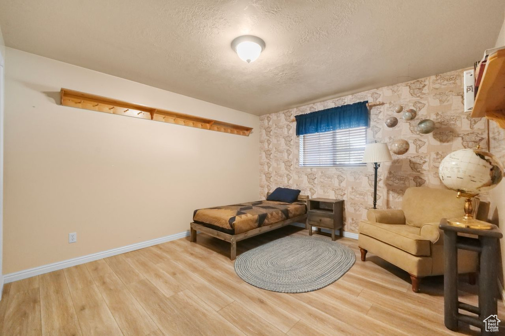 Sitting room with a textured ceiling, wood finished floors, and baseboards
