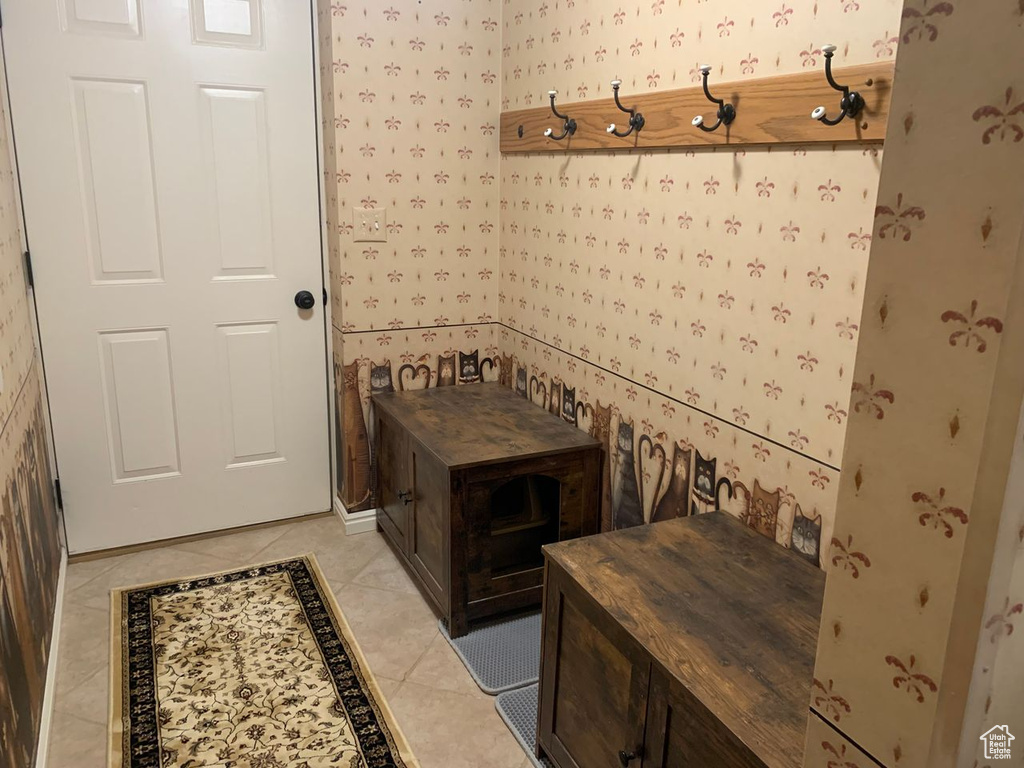 Mudroom featuring wallpapered walls and light tile patterned flooring