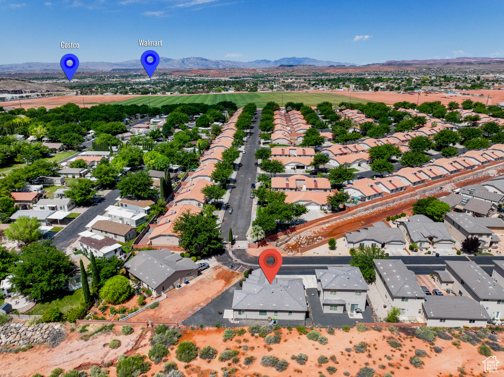 Aerial view of property\'s location with nearby suburban area and a mountainous background