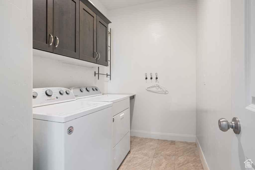 Laundry area with independent washer and dryer, cabinet space, and baseboards