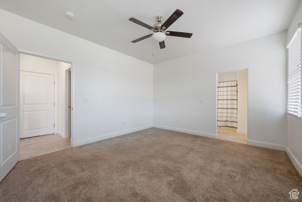 Unfurnished room featuring carpet floors, ceiling fan, a smoke detector, and baseboards
