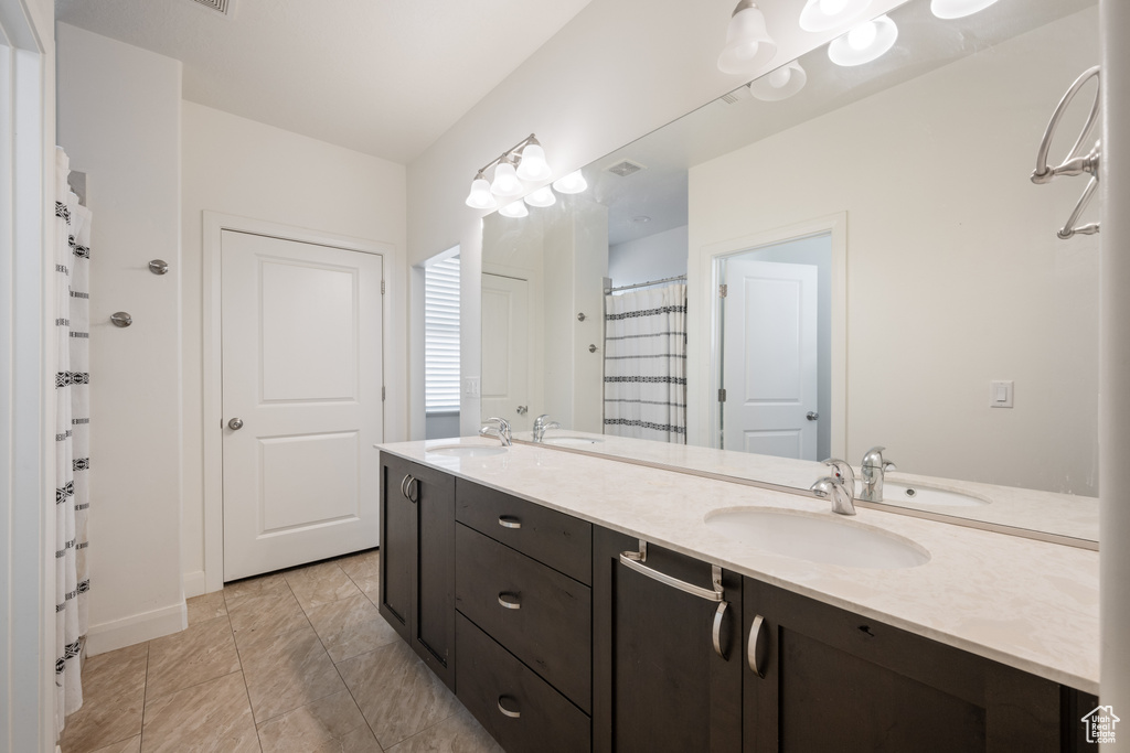 Full bathroom with double vanity and curtained shower