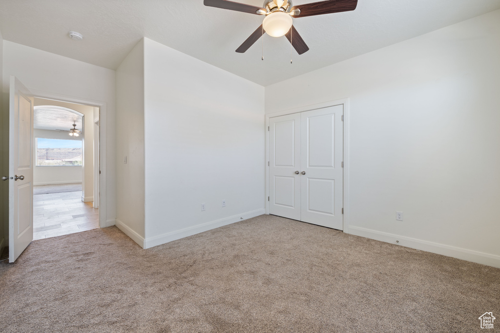 Unfurnished bedroom featuring carpet flooring, baseboards, a ceiling fan, and a closet