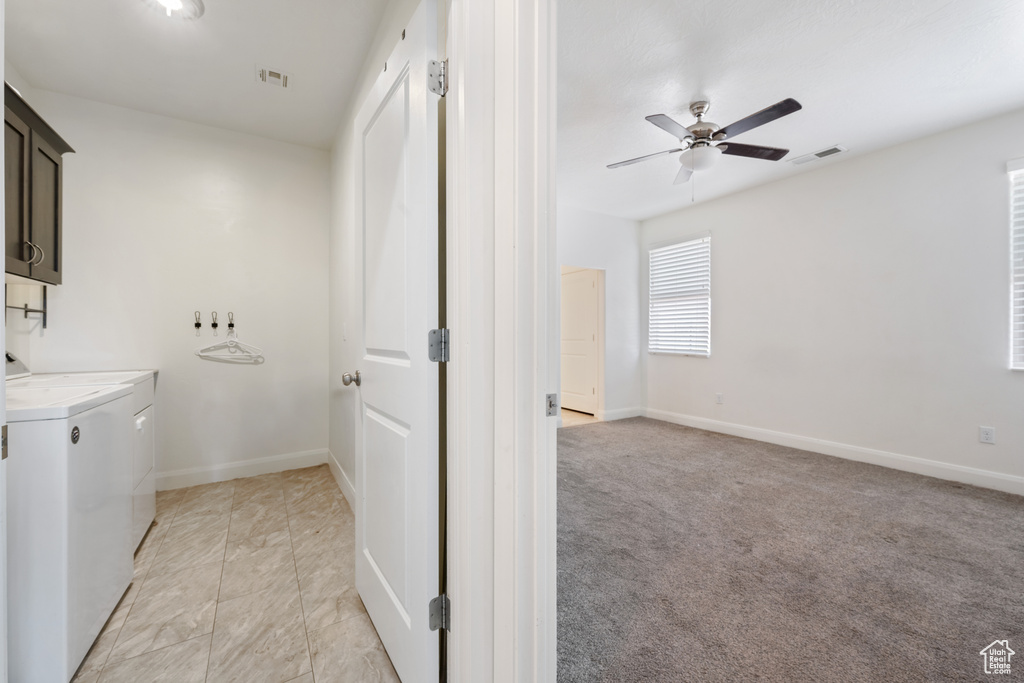 Laundry room with independent washer and dryer, cabinet space, ceiling fan, and baseboards