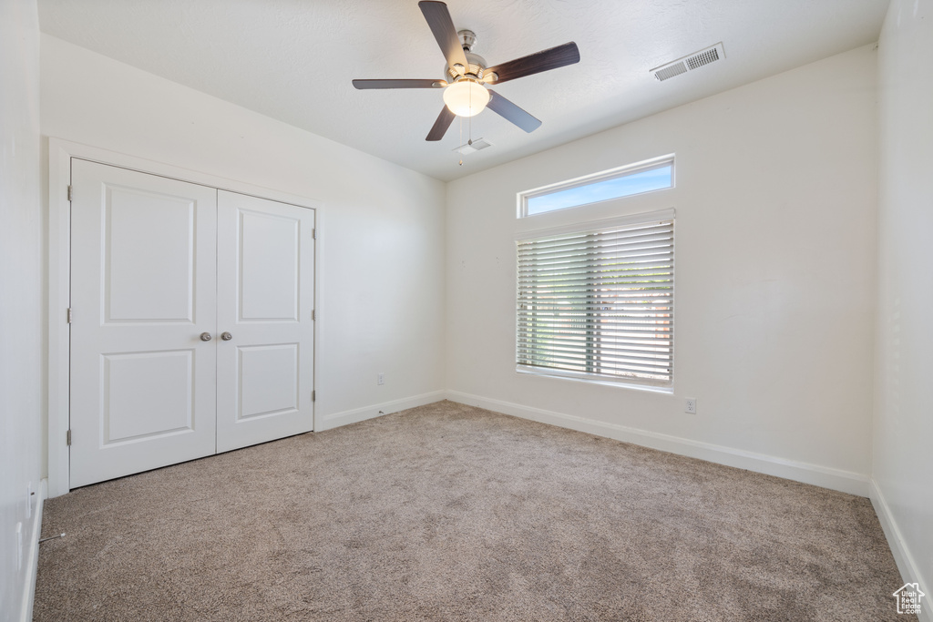 Unfurnished bedroom with carpet flooring, baseboards, a closet, and ceiling fan
