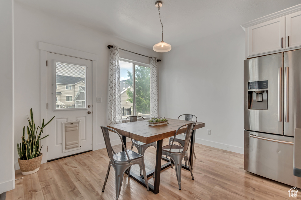 Dining area with light wood-style floors and baseboards