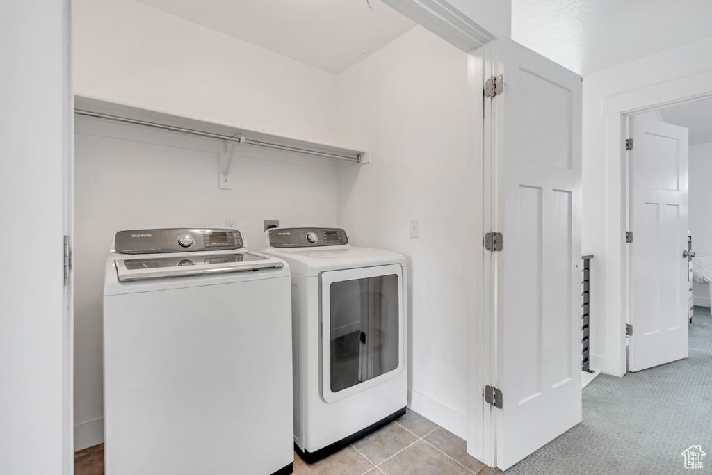 Laundry room with washer and clothes dryer and baseboards