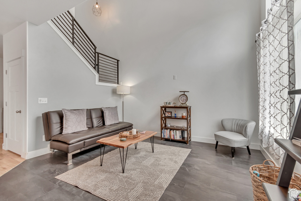 Living area featuring a high ceiling and baseboards