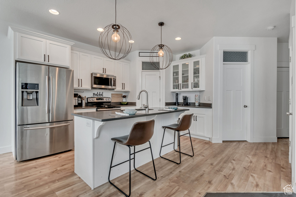 Kitchen featuring appliances with stainless steel finishes, dark countertops, white cabinets, and recessed lighting