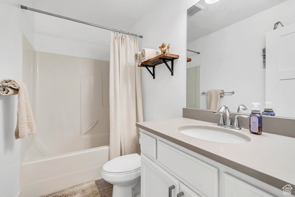 Full bath featuring vanity, shower / tub combo, and toilet