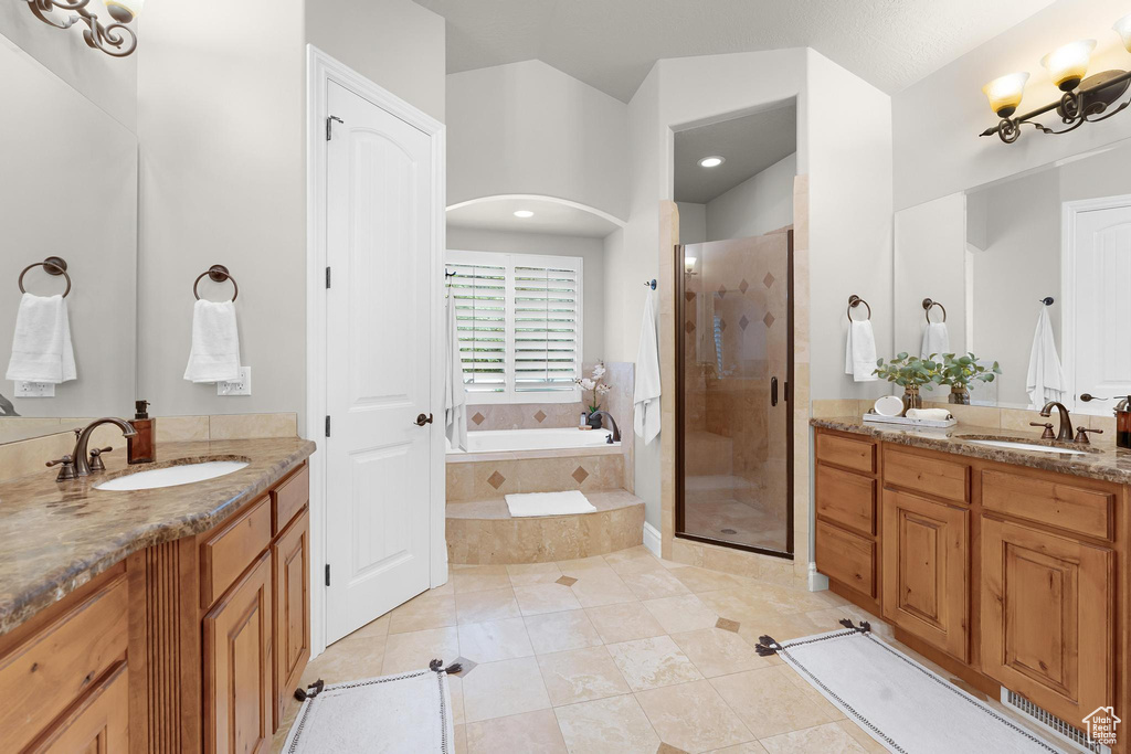 Bathroom with two vanities, a shower stall, a garden tub, tile patterned floors, and recessed lighting